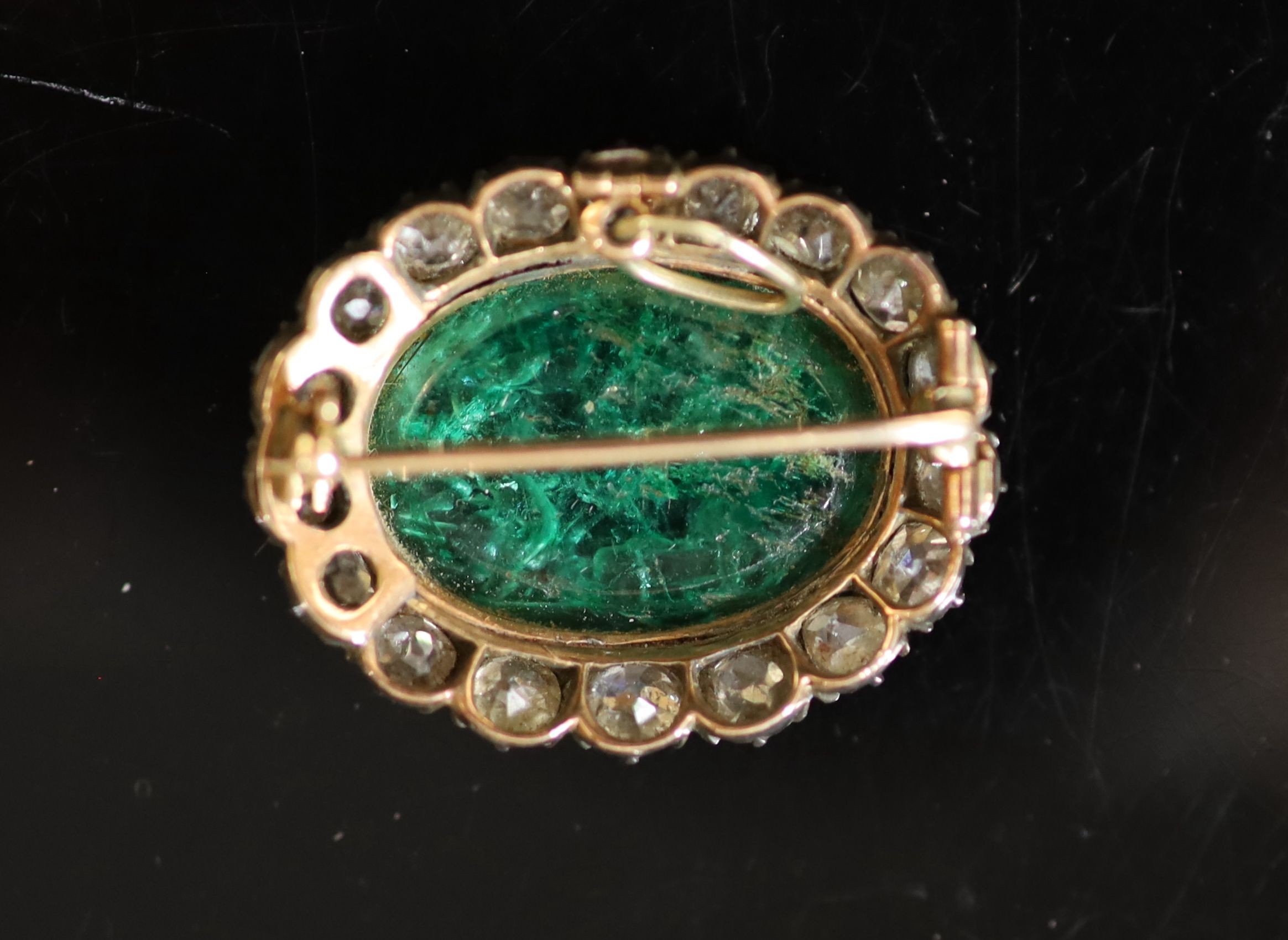 A possibly Roman oval intaglio emerald, mounted in an early Victorian gold, silver and diamond set oval pendant brooch